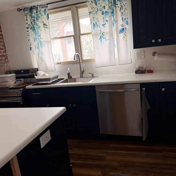 Modern navy blue kitchen with stainless appliances cleaned